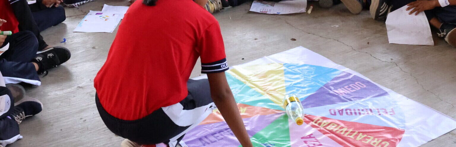 Niñas y niños de primaria juegan "la ruleta de las emociones".