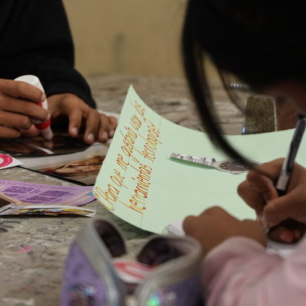 Dos jóvenes adolescentes haciendo un collage sobre violencia digital.