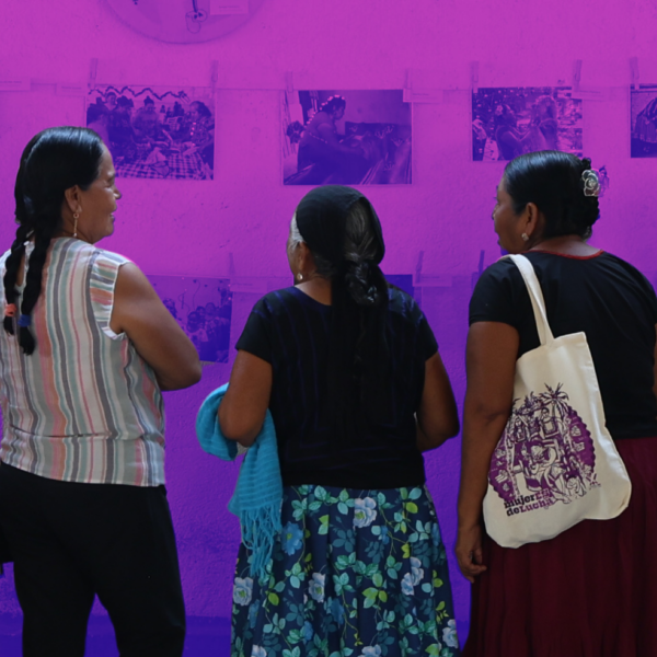 5 mujeres de espaldas, obsevando una exposición de fotobordado