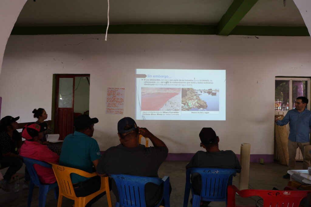 Mujeres y hombres viendo información sobre el agua proyectada en la pared.