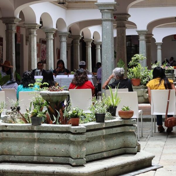 personas sentadas hablando, en el patio de la biblioteca Margharita Maza