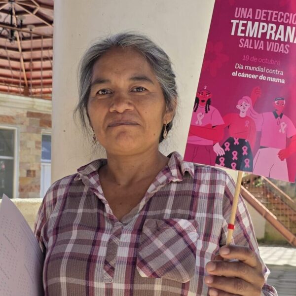 Mujer sosteniendo cartel con la frase "Una detección temprana salva vidas"