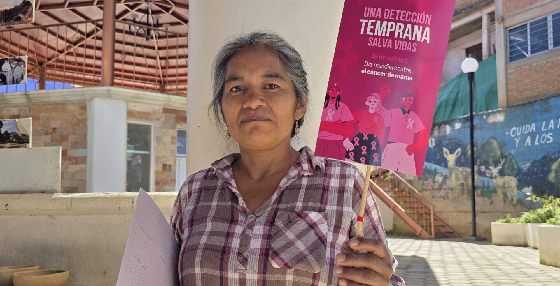 Mujer sosteniendo cartel con la frase "Una detección temprana salva vidas"
